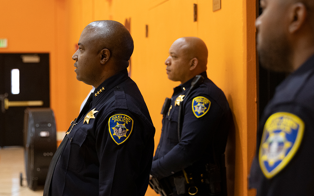 Oakland Police Chief LeRonne Armstrong, left, watches a basketball practice inside his former high school, McClymonds High School, in Oakland, Calif. In his earlier days, Armstrong used to play basketball on a regular basis. (Photo by Diannie Chavez/News21)