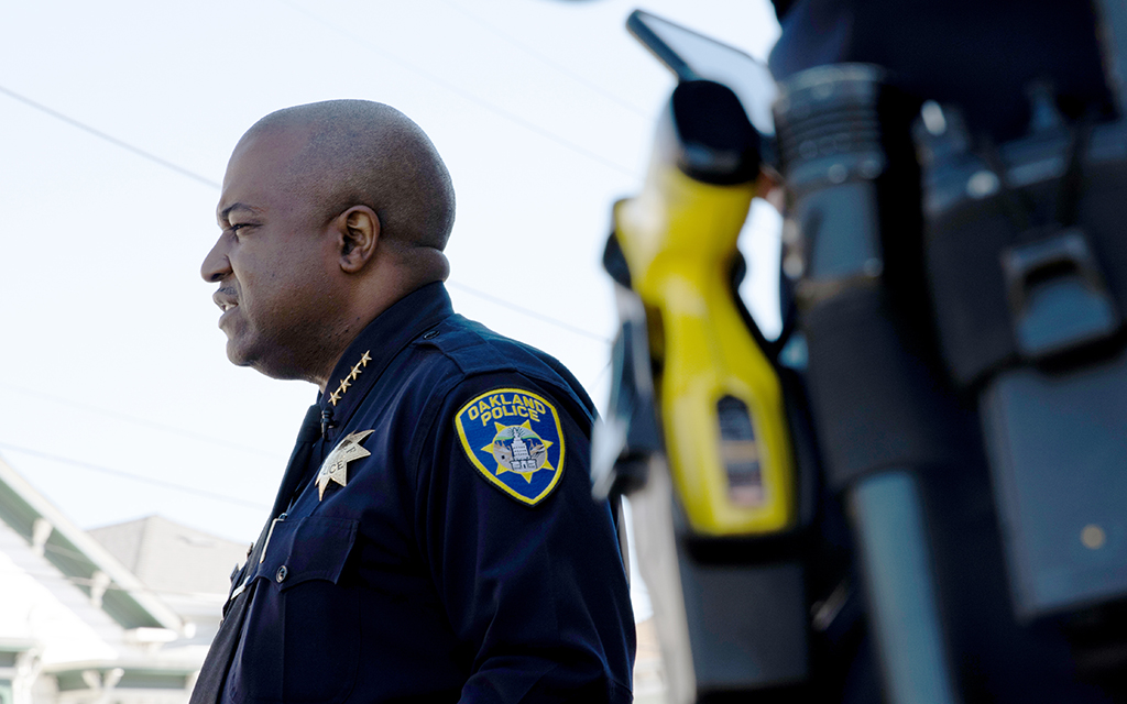 Oakland Police Chief LeRonne Armstrong is photographed in his childhood neighborhood in West Oakland on June 28, 2022. Nearby, several of his officers stand guard. (Photo by Diannie Chavez/News21)