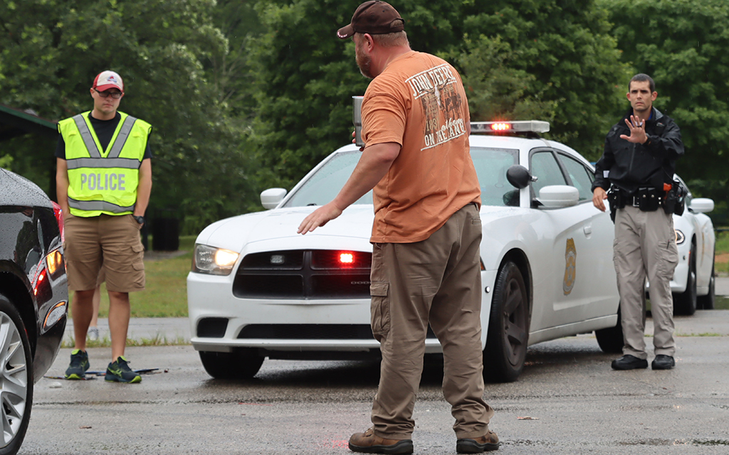 Paul Goodrich, a recruit with the Indianapolis Metropolitan Police Department, addresses field training officer Andrew Lamle during an exercise called Unknown Traffic Stop on Friday, July 8, 2022, while field training officer Joseph Dransfield looks on. It simulates real-life scenarios officers often encounter in the field. (Photo by Mikey Galo/News21)