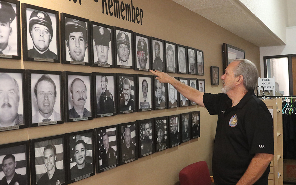 Joe Clure, the executive director of the Arizona Police Association, looks at photos of officers killed in the line of duty. The organization describes itself as “an association of associations.” (Photo by Sarah Emily Baum/News21)